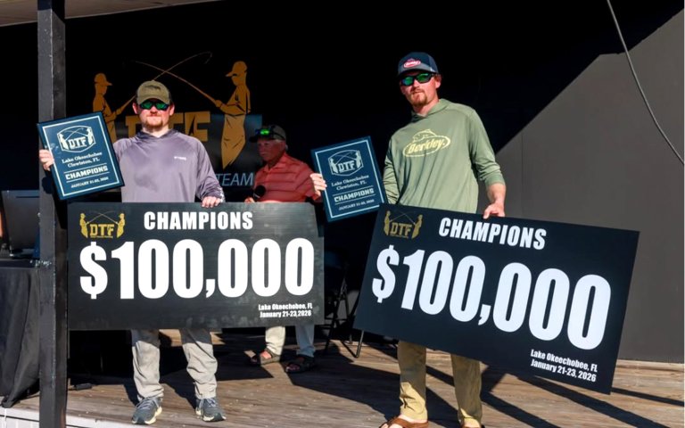 A team of bass anglers holds up novelty checks.
