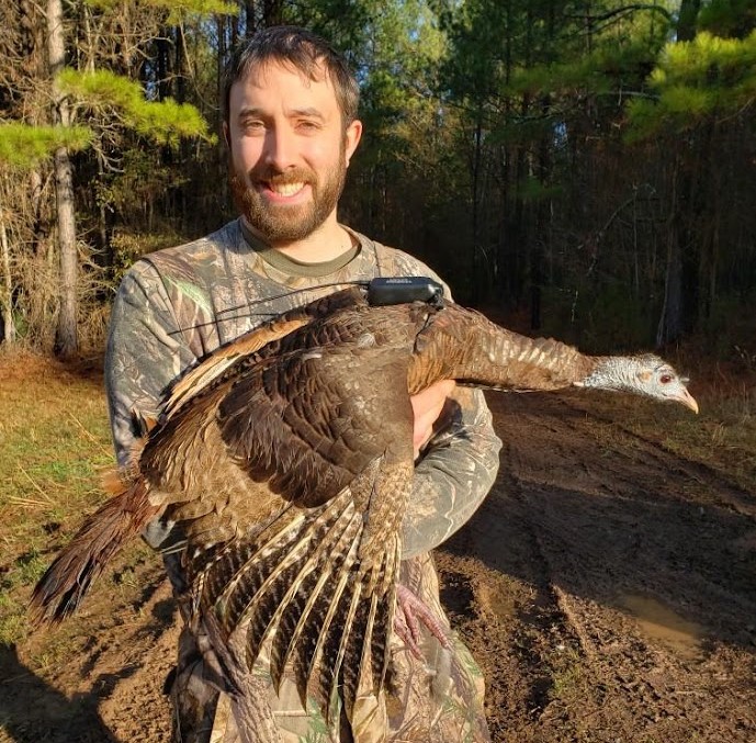 Patrick Wightman holds a hen turkey with a backpack radio.