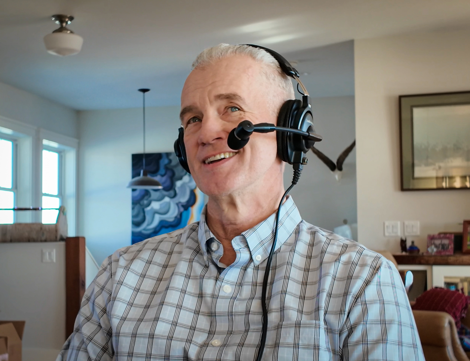 A photo of randy newberg with a headset on for a podcast.