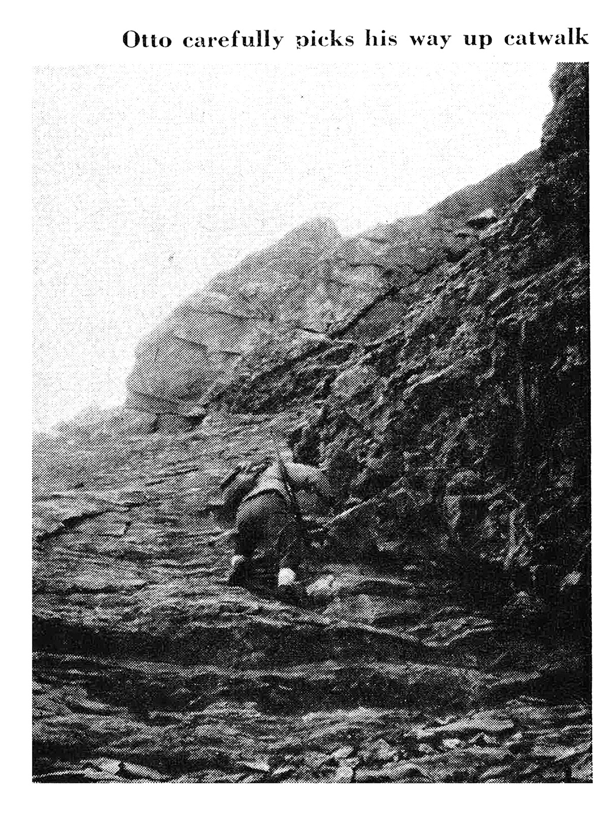 A black and white photo of a hunter climbing a steep wall.