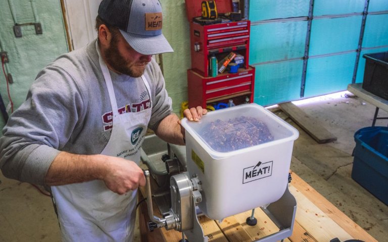 A man used a meat mixer to ensure even coverage of seasonings