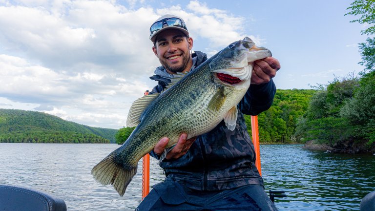 An angler holding a big spring largemouth bass.