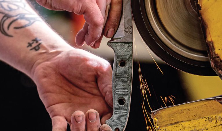 A Benchmade knifemaker grinds a knife.