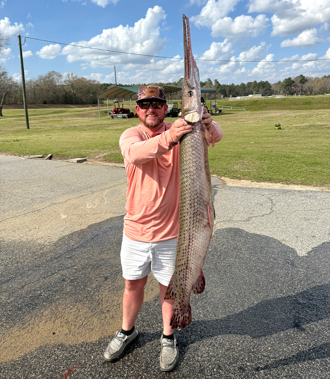An angler holds up a state-record longnose gar.