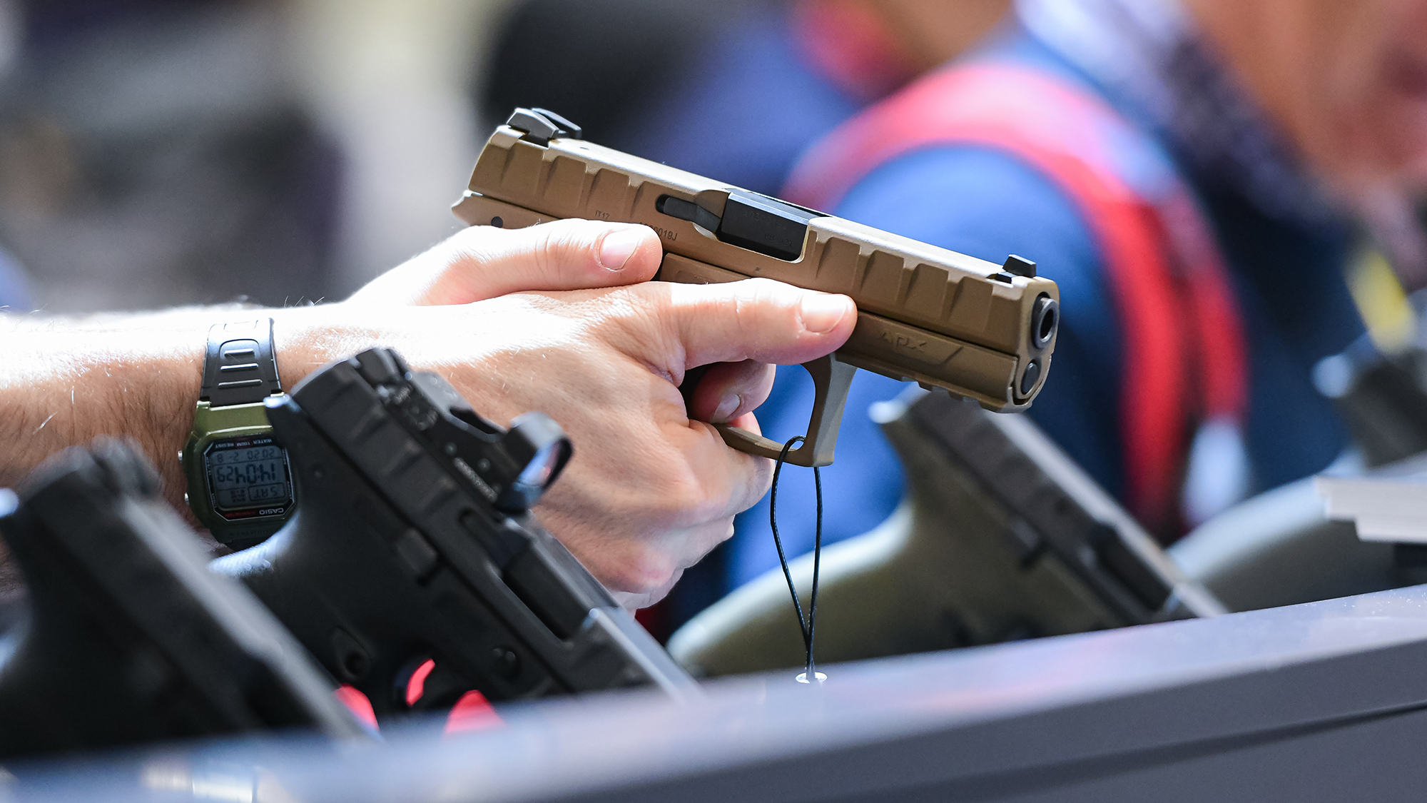A man tries the Beretta APX, a striker-fired semi-automatic pistol, on display at Hit Show 2020, trade fair show dedicated to hunting, target sports and outdoor