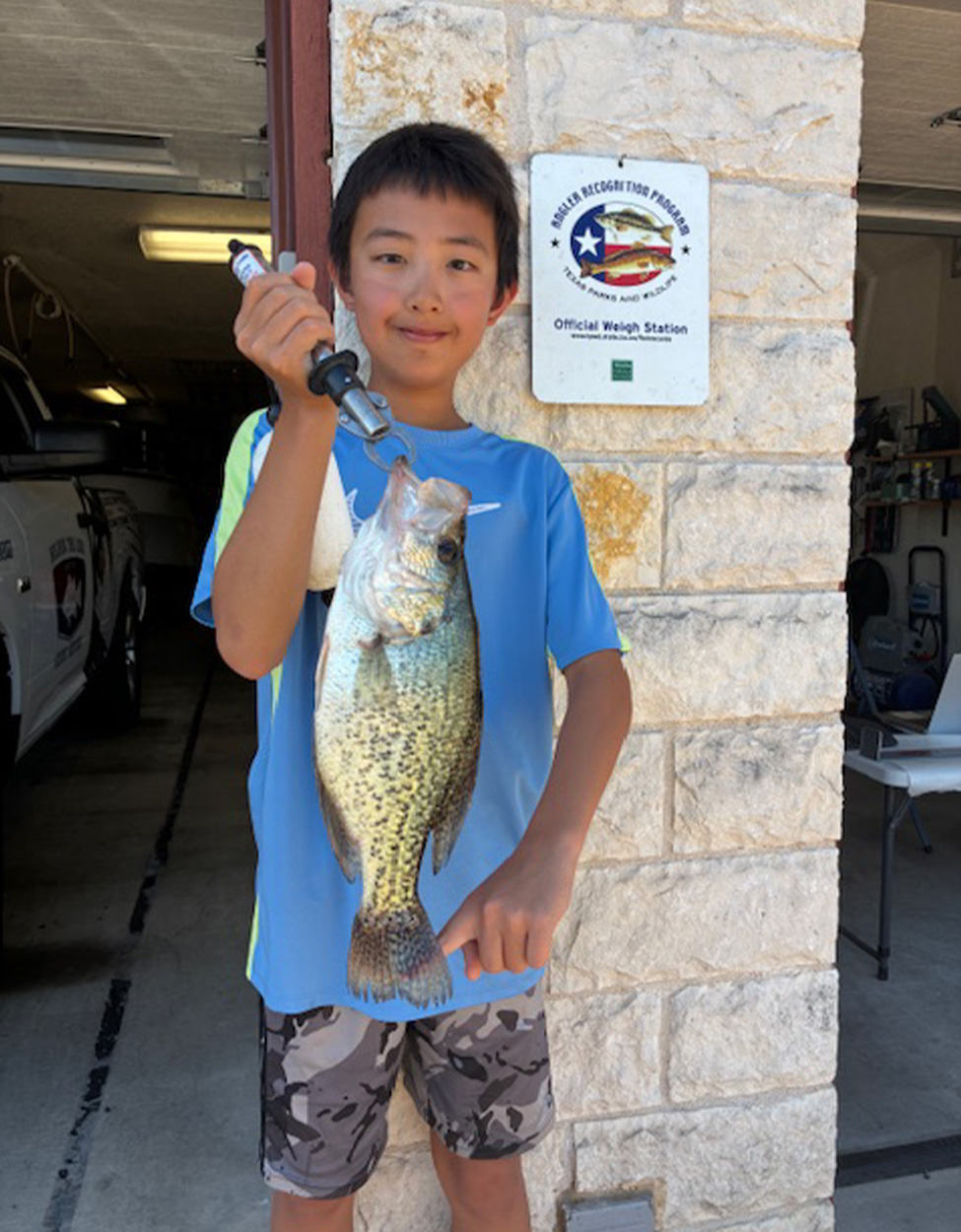 A young angler holds up a pending junior record crappie.
