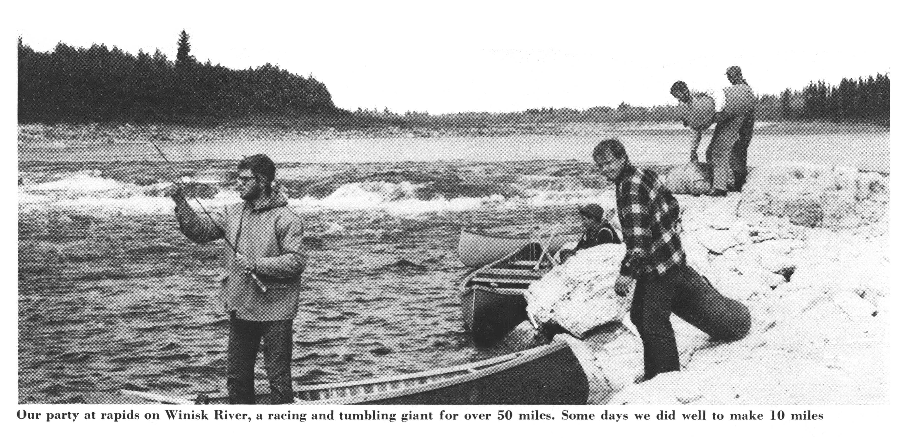 A black and white photograph of canoers by the river.