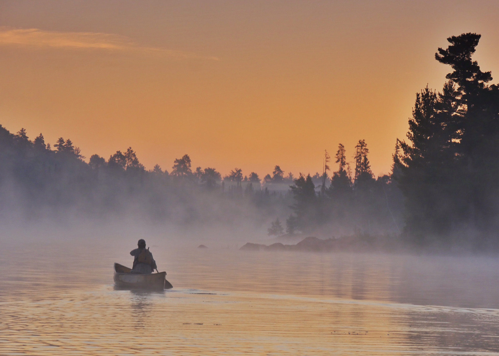 A lone canoeist on a lake in the Boundary Waters.