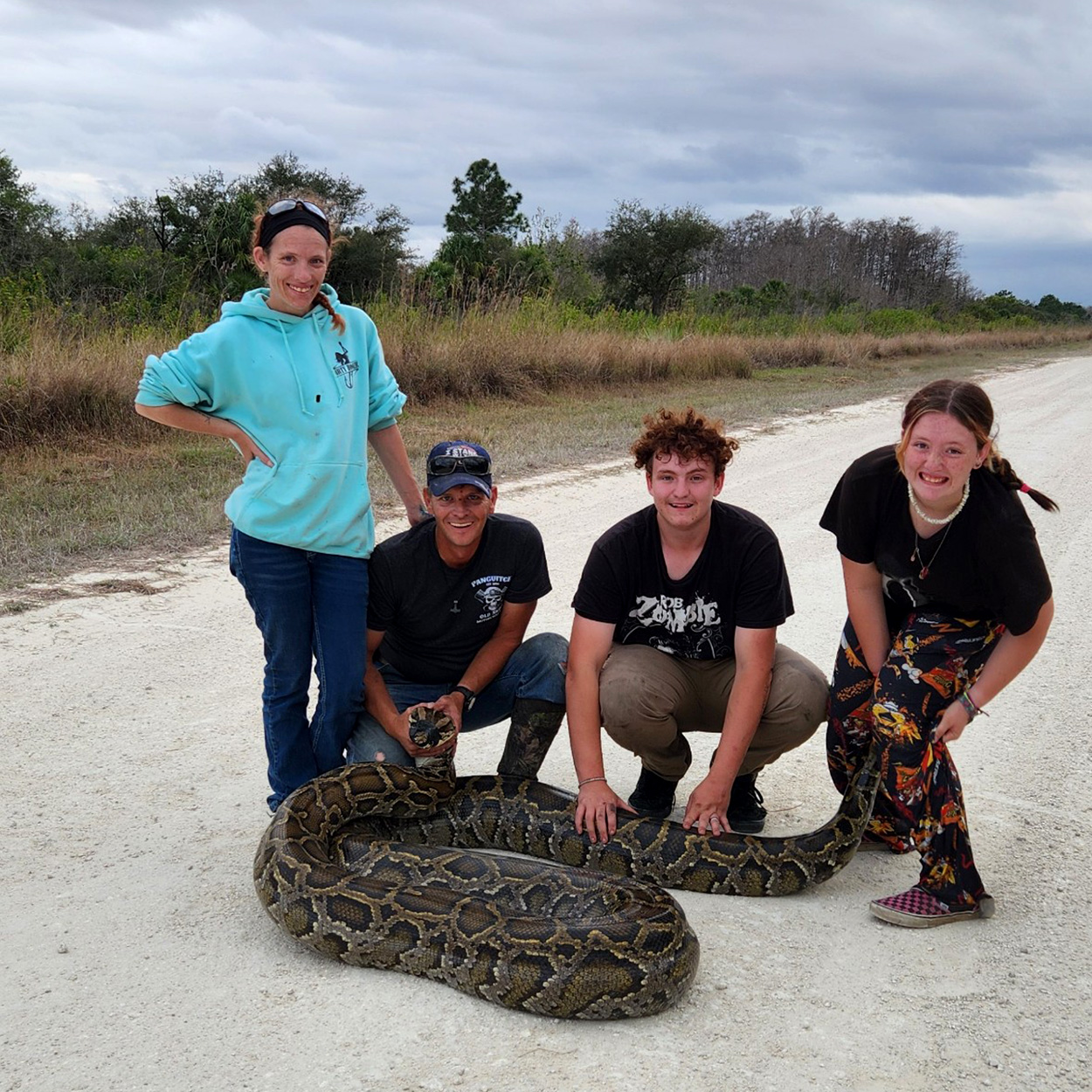 A family of python contractors with a huge snake.