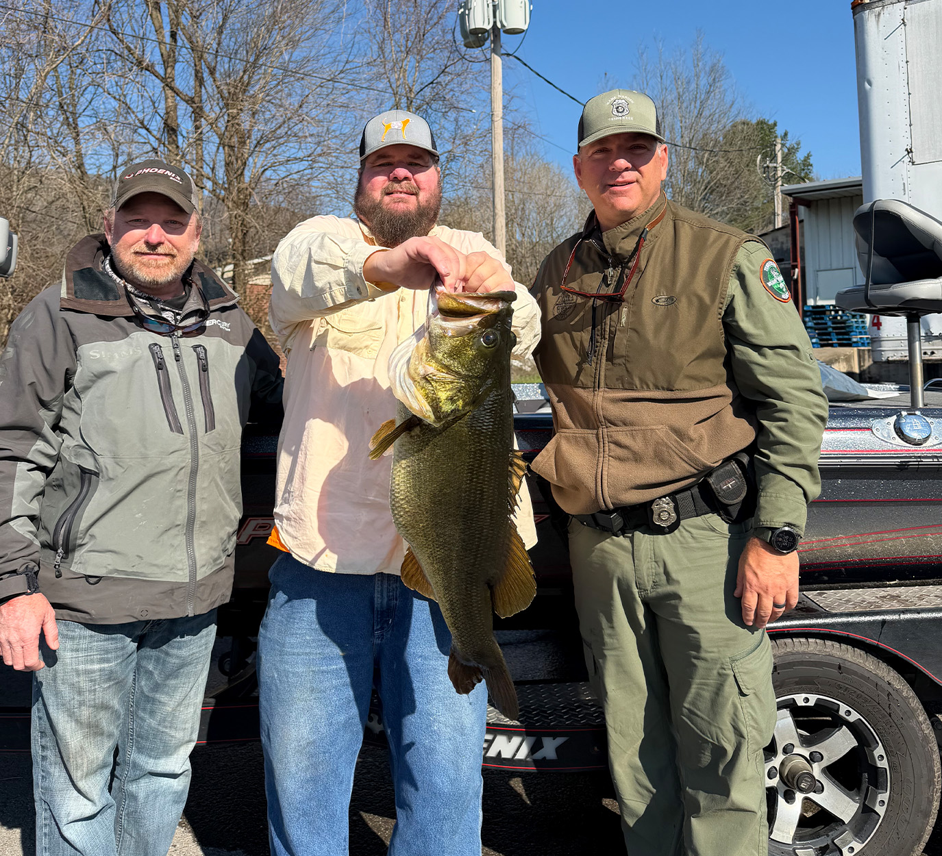 Two anglers and a wildlife official with a state-record bas.
