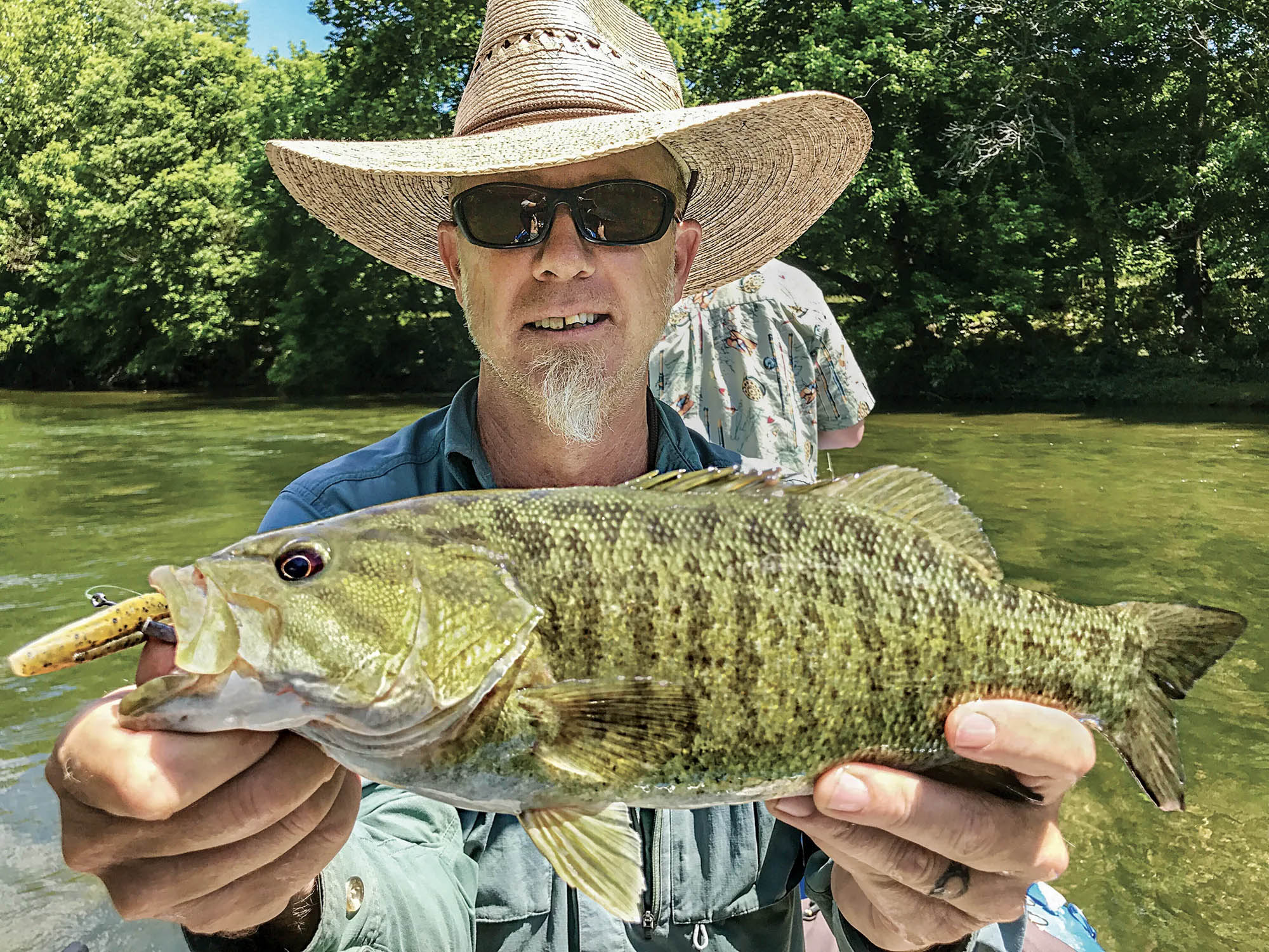 A fishing guide holds up a nice bronzeback