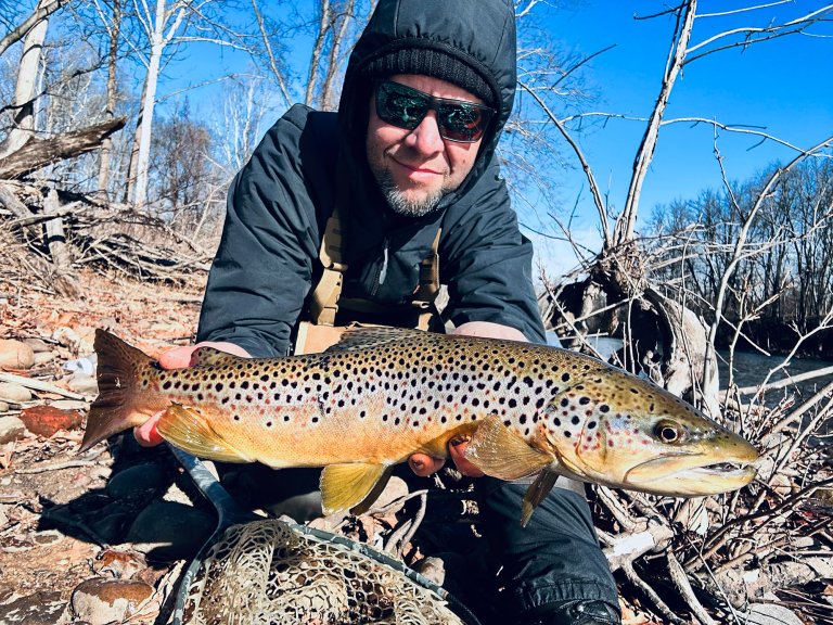 Joe Cermele holds up a nice trout on a cold day between winter and spring.