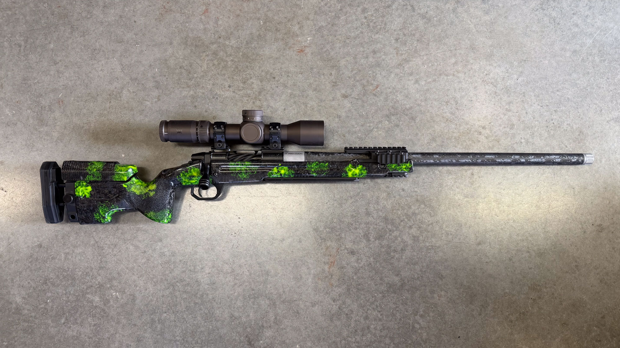 A custom 25 Creed with green camo paint on a black rifle body