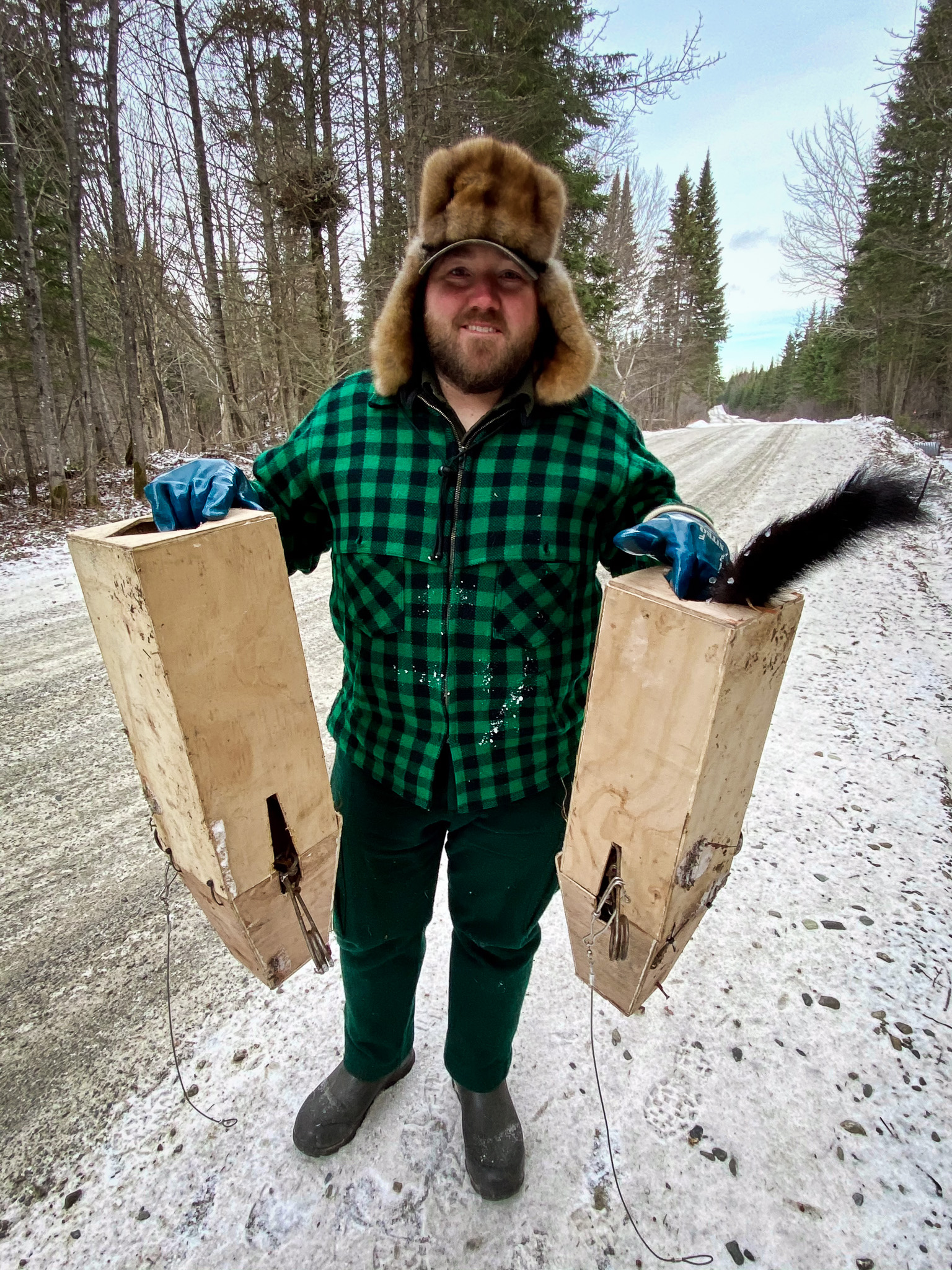 A Maine trapper with two trapping boxes.
