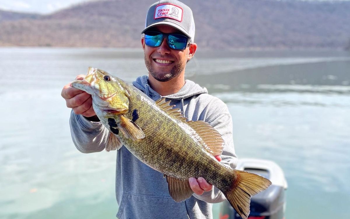 The author holds up a smallmouth bass he caught with a spinnerbait.