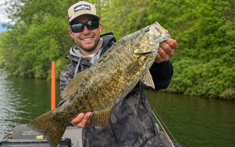 an angler with a large smallmouth he caught on a squarebill