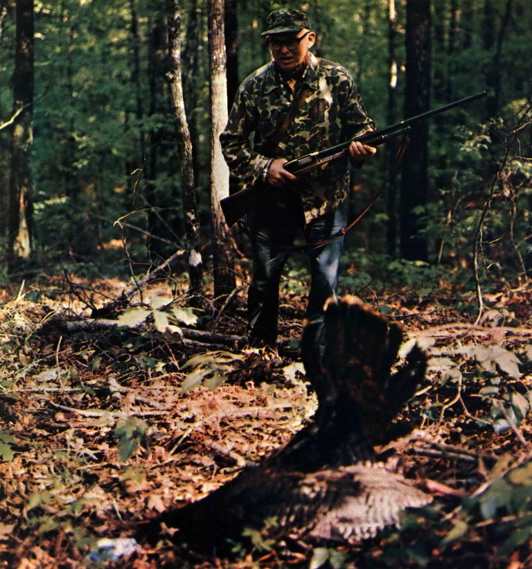 an old photo of Charlie Elliott walking up on a turkey in the woods