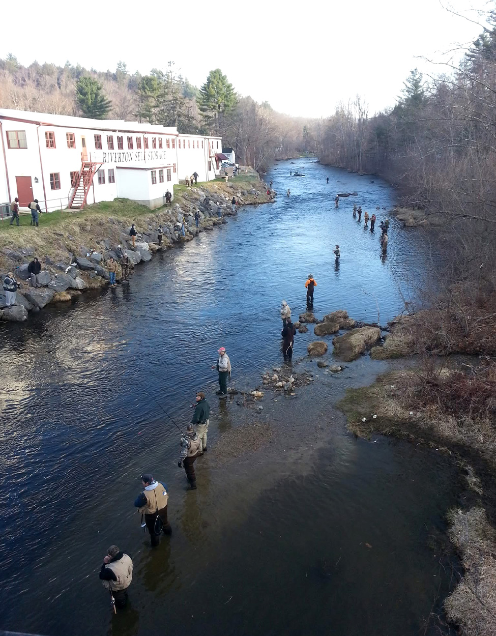 Anglers fishing shoulder to shoulder on a river in Connecticut.