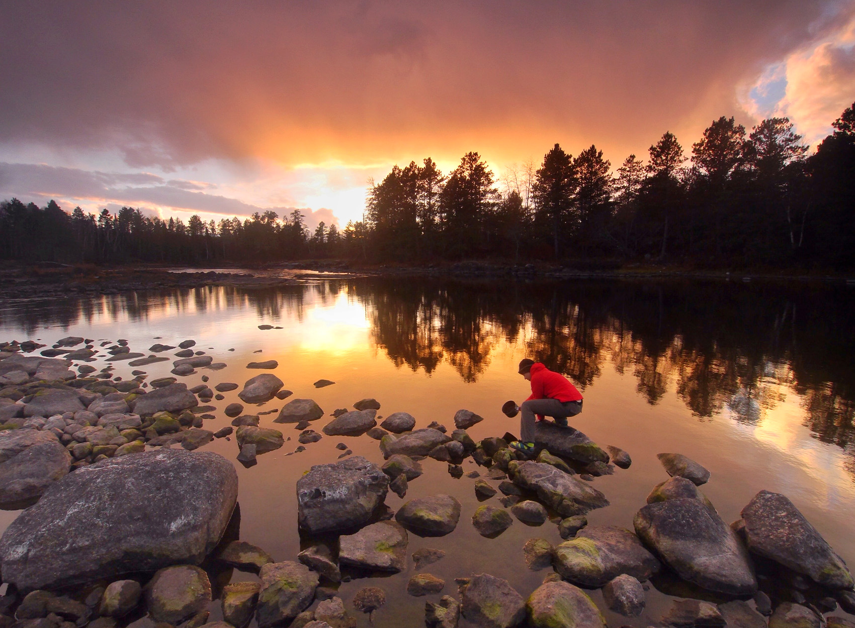 A paddler collects water from a lake in the Boundary Waters.
