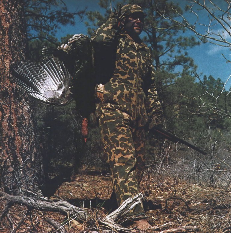 A vintage photo of a turkey hunter in old-school camo.