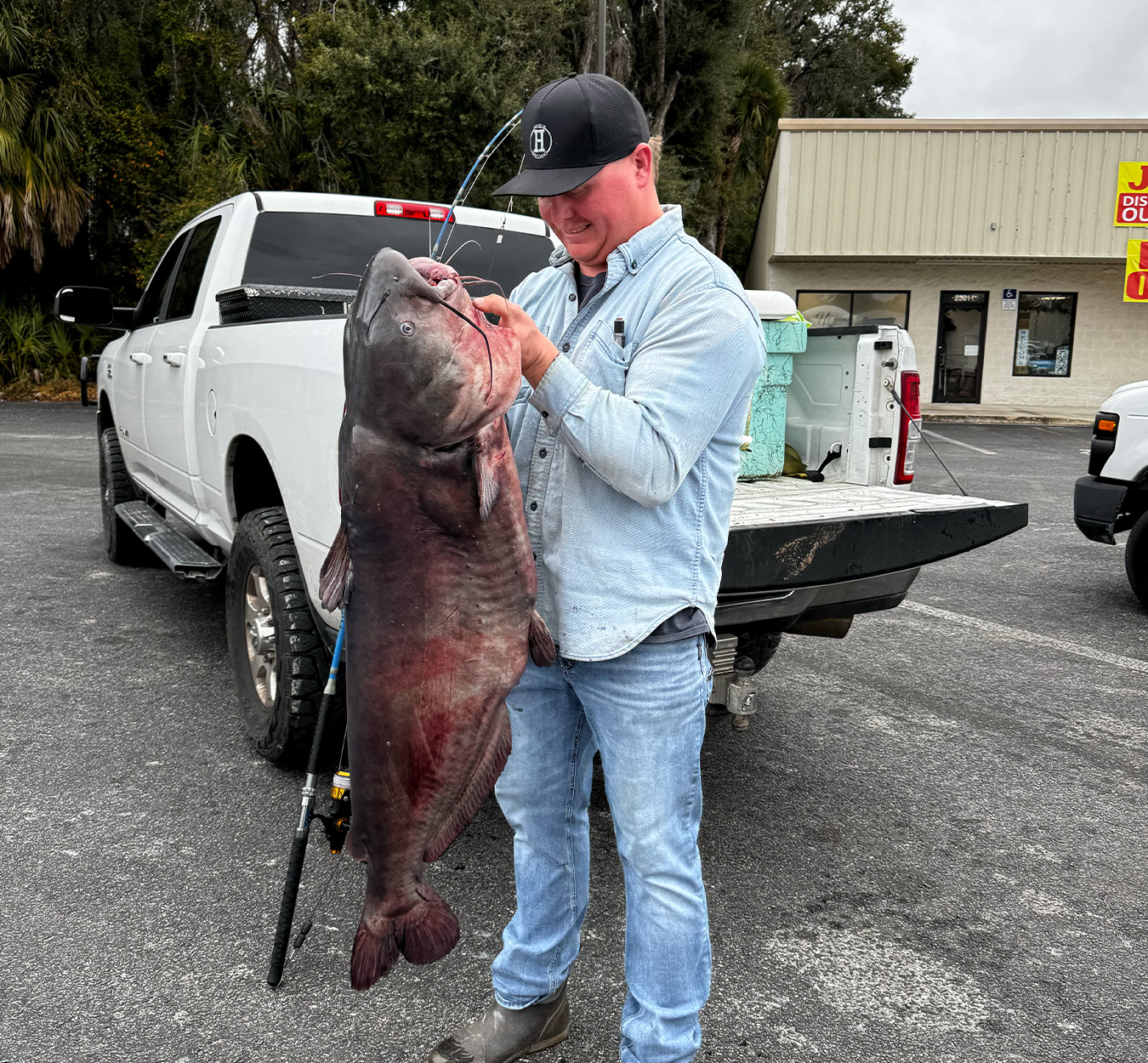 A fisherman with a big catfish at a boat ramp in Florida.