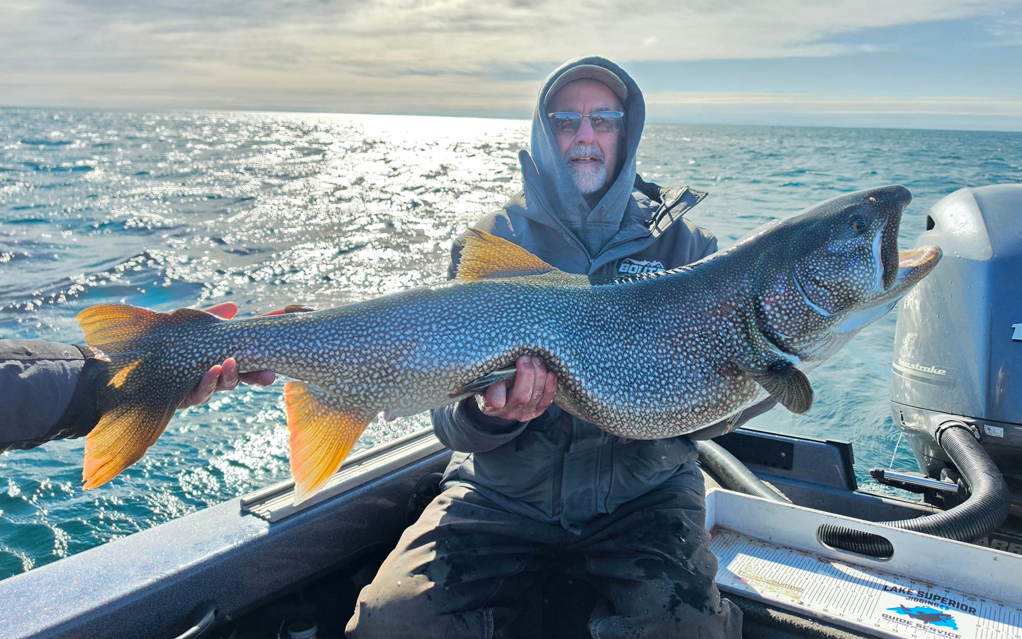 An angler with a state-record lake trout on Lake Superior.