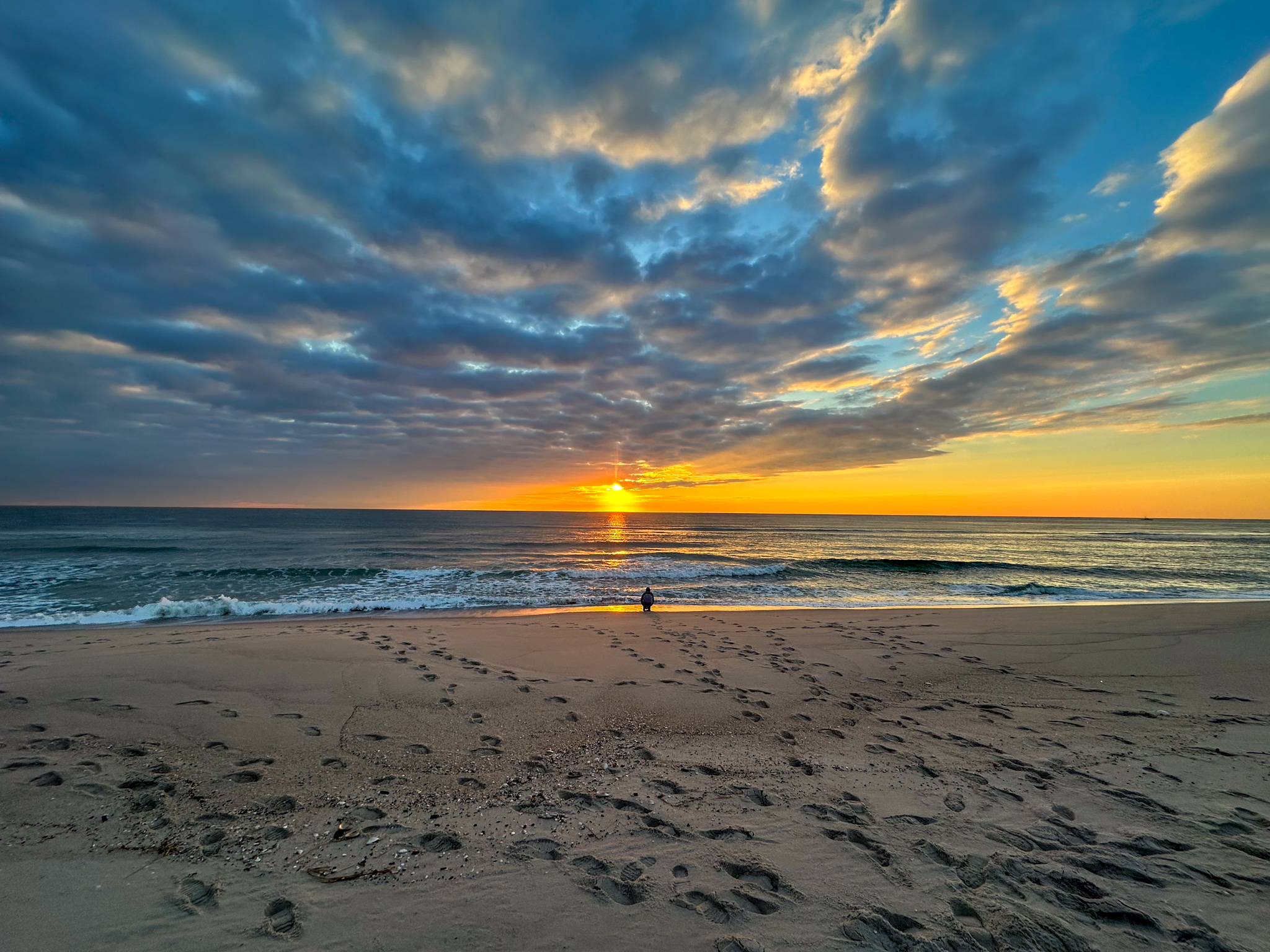 A surf fisherman laong the beach.