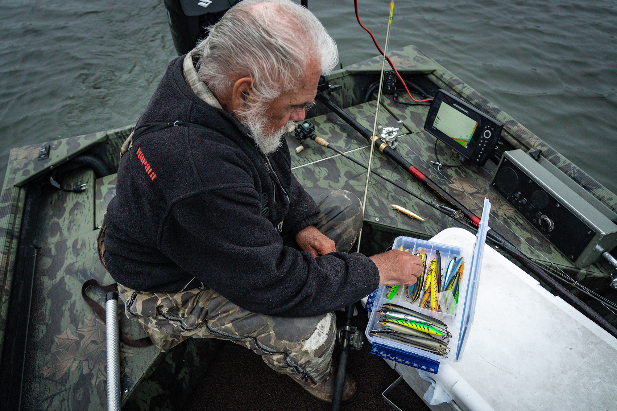 The Griz picks through a tackle box on a boat.