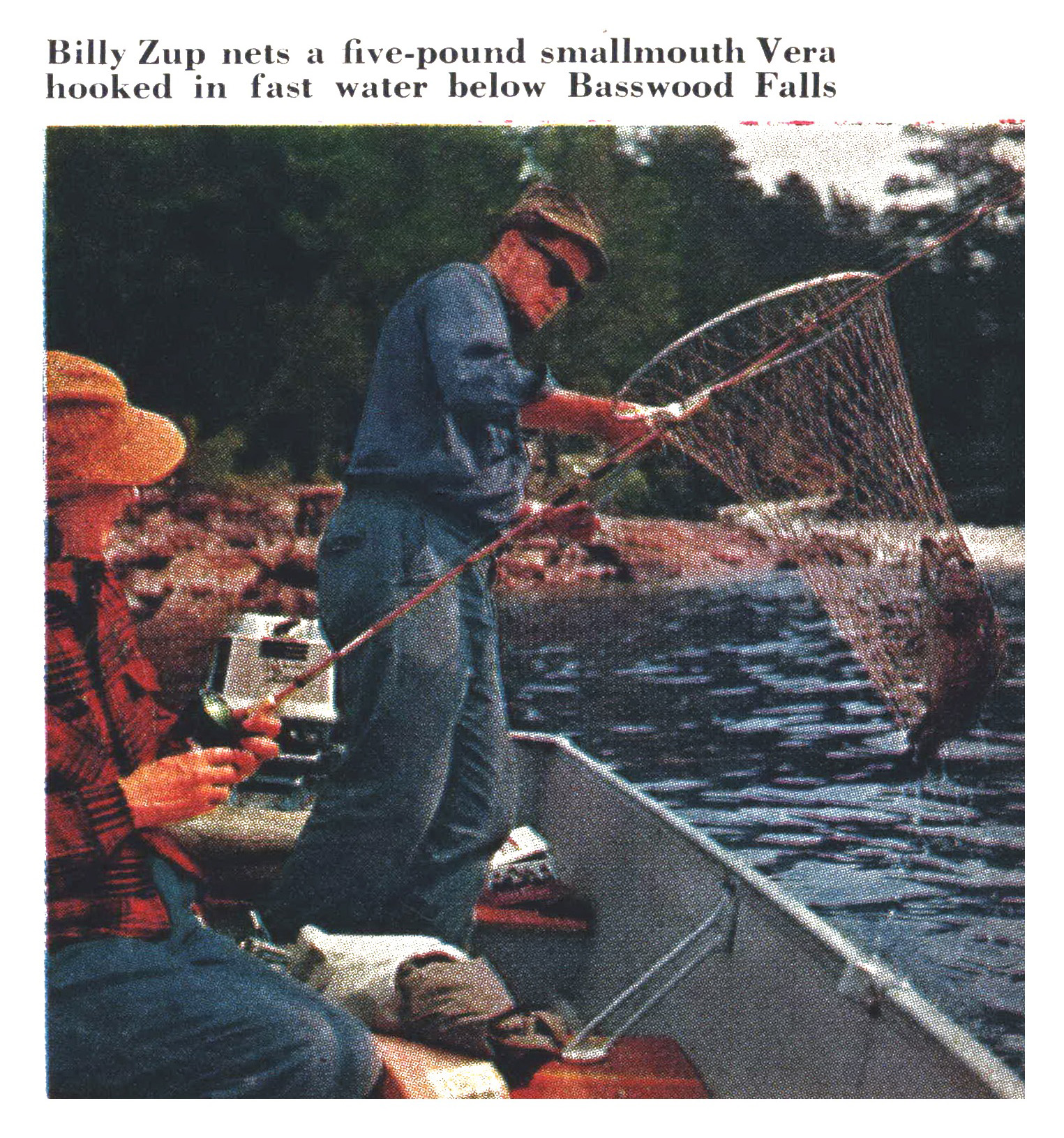 Guide Billy Zup leans from a boat to net a five-pound smallmouth in the fast water below Basswood Falls.