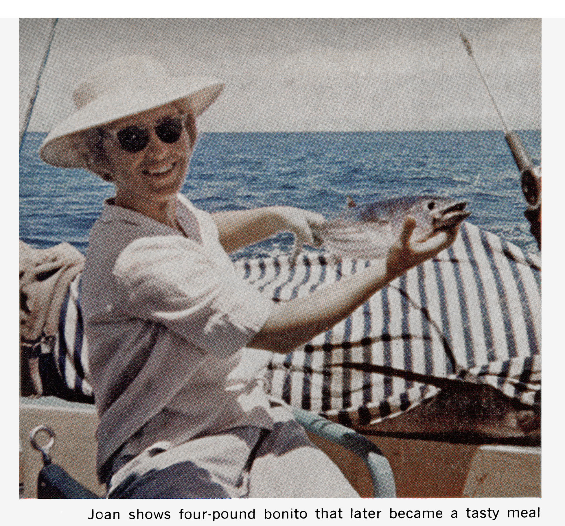 A color photo of a woman holding up a bonito.