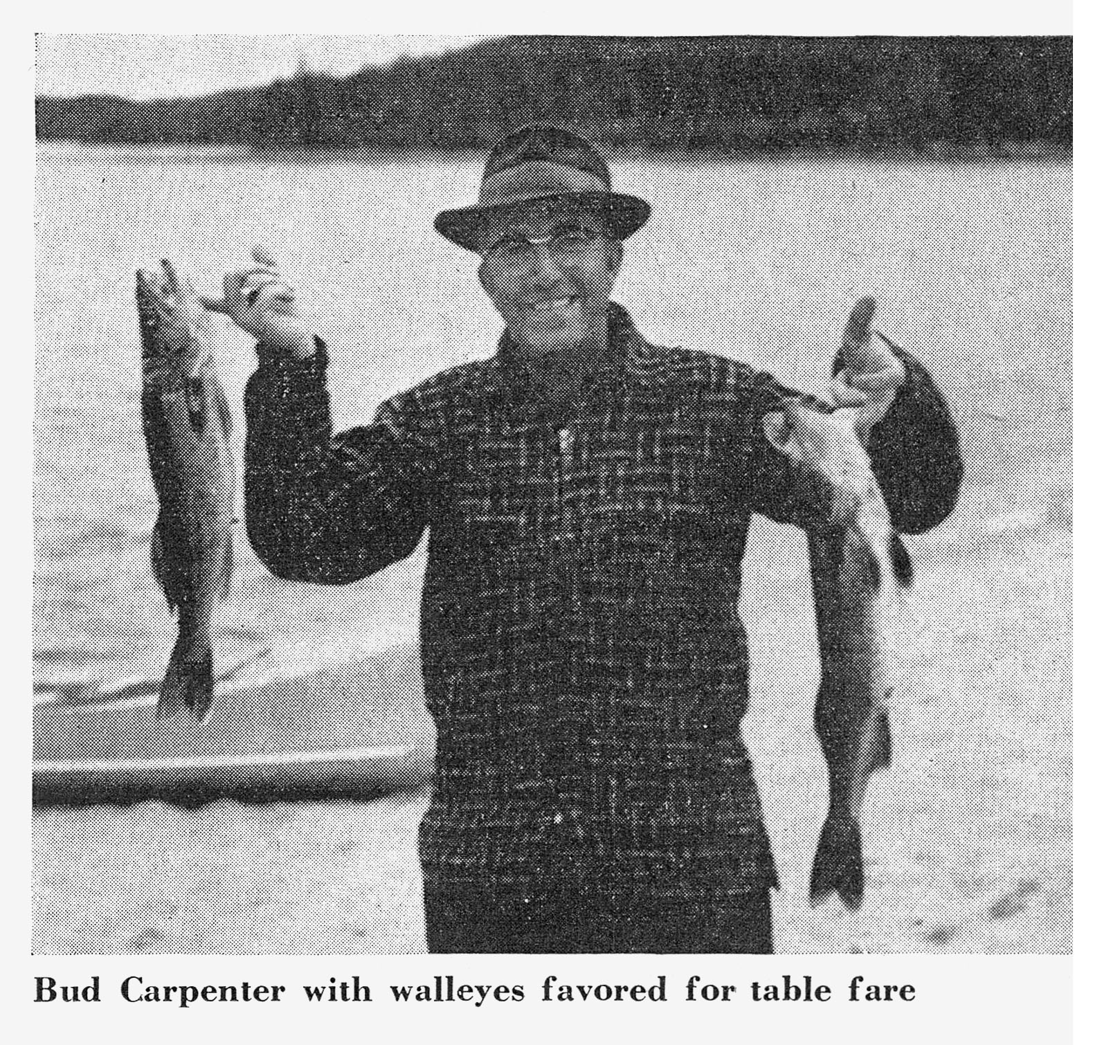 Angler Bud Carpenter smiles holding up a walleye in each hand on the lakeshore.