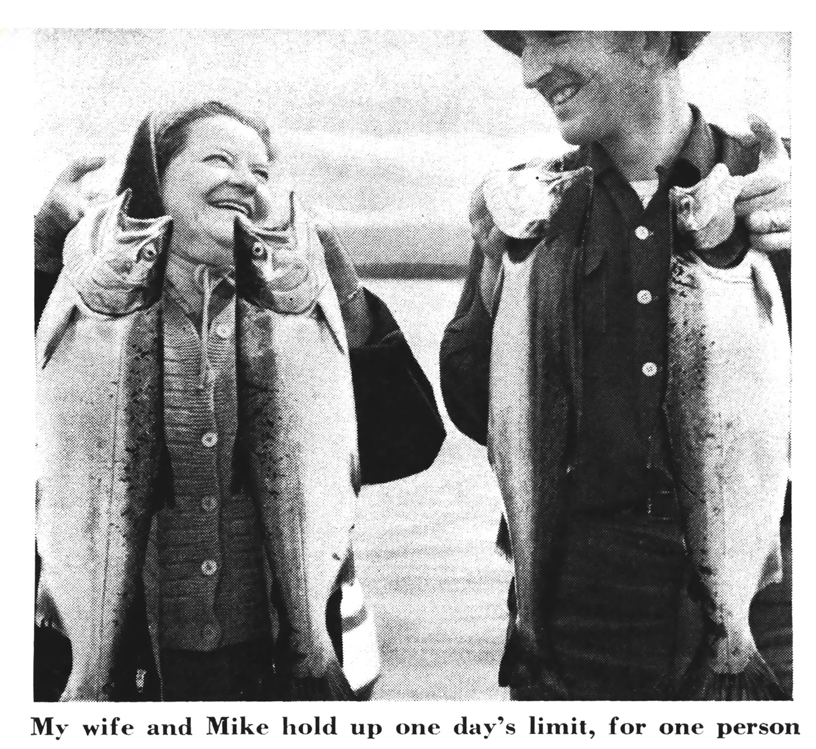 A vintage black and white photo of a woman and a guide holding up salmon