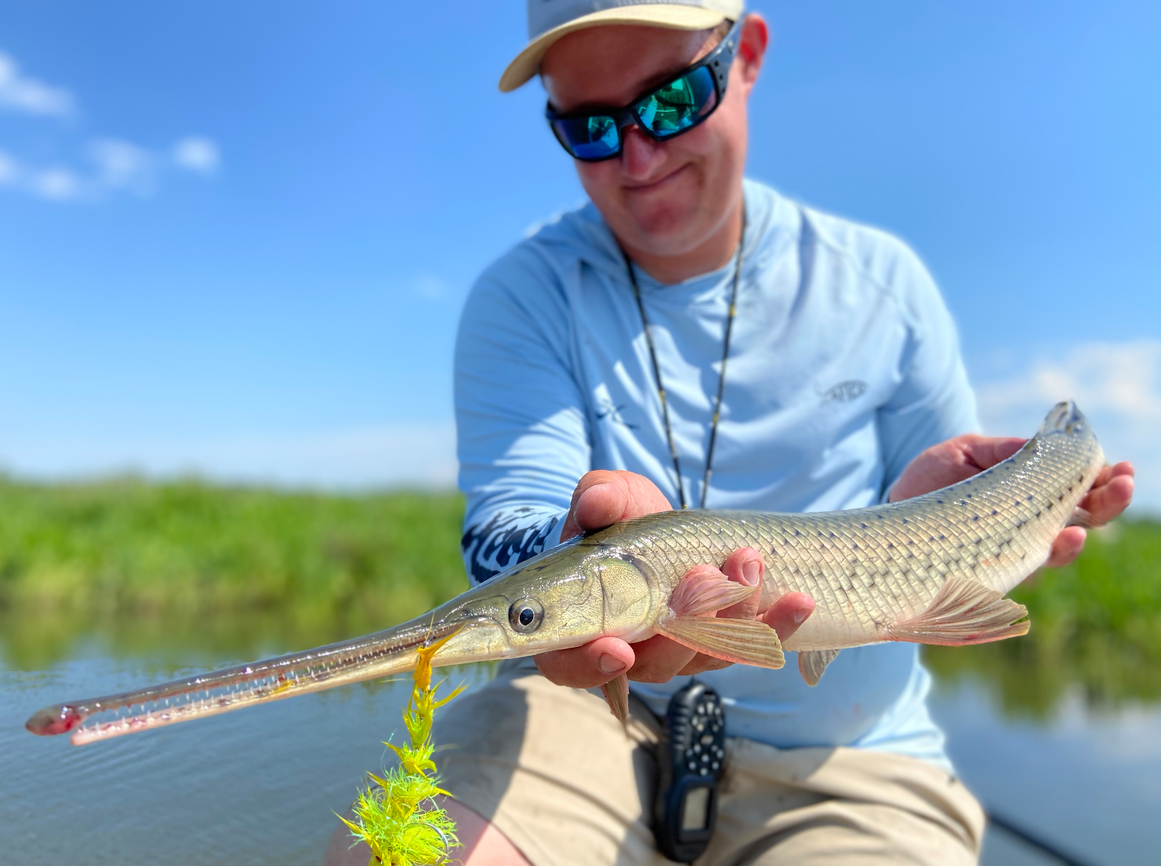 A fisherman holds a longnose gar.