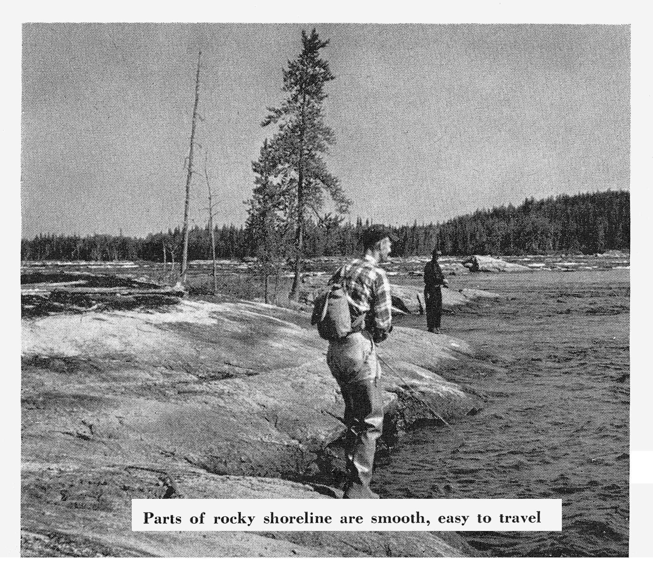 Two anglers walk and fish along a broad, smooth expanse of rock shoreline beside the river.