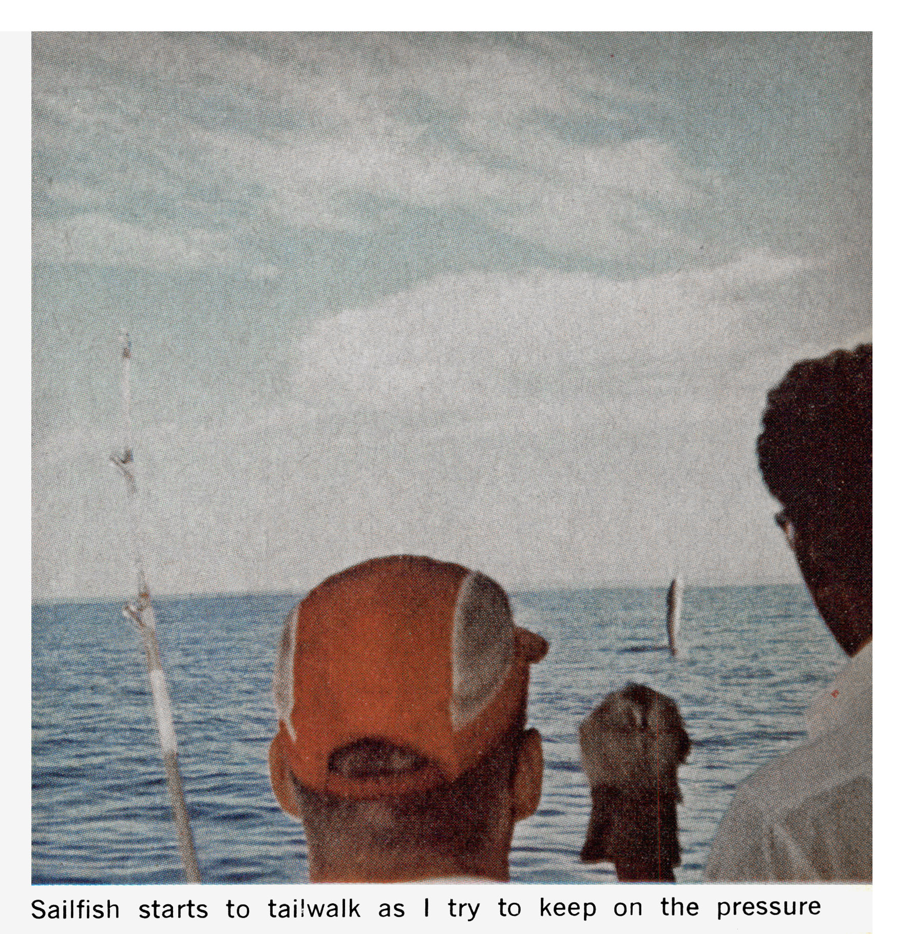 A color photograph of a man fighting a marlin.