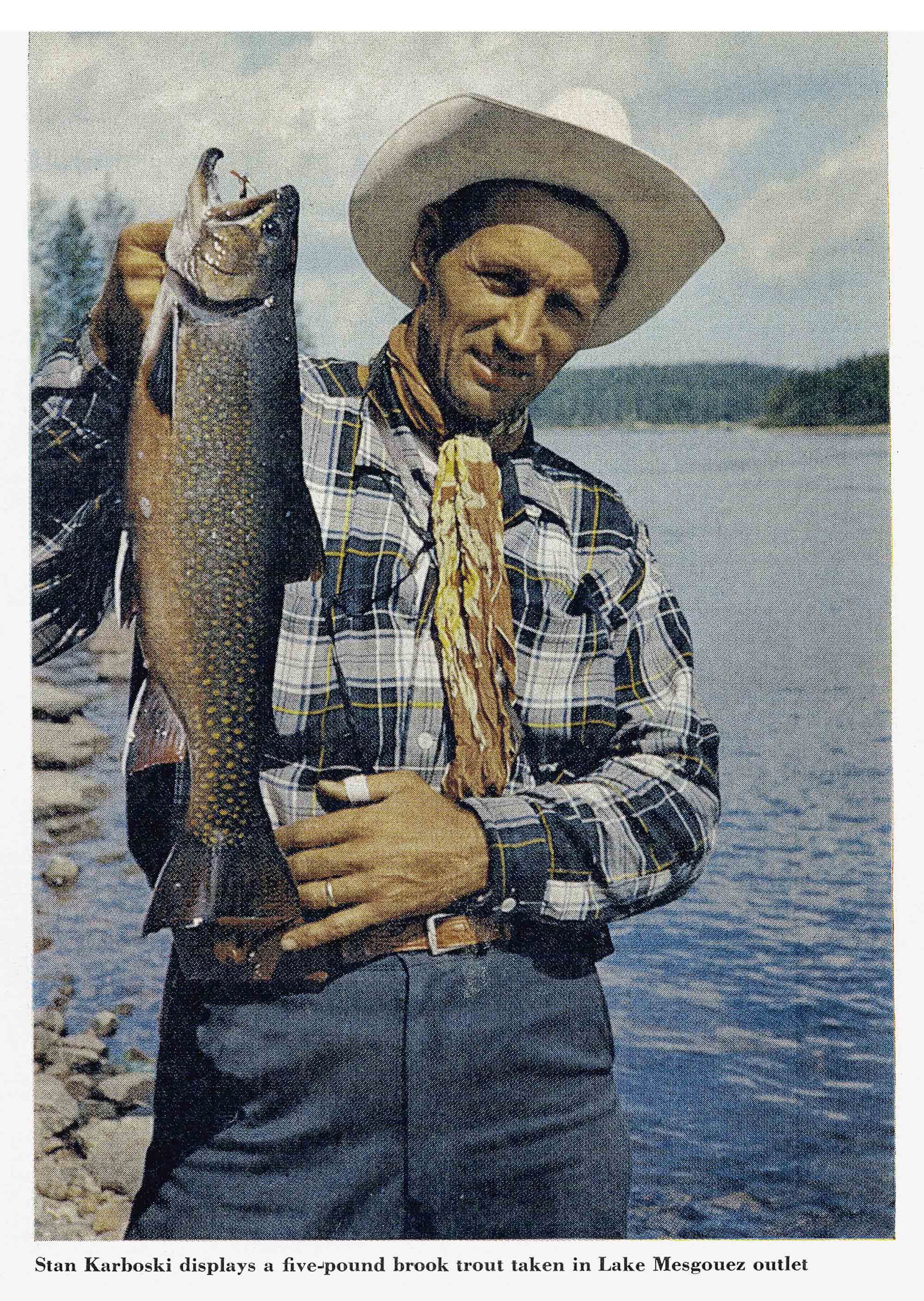 Angler Stan Karboski in a plaid shirt and hat holds up a five-pound brook trout taken at the Lake Mesgouez outlet.