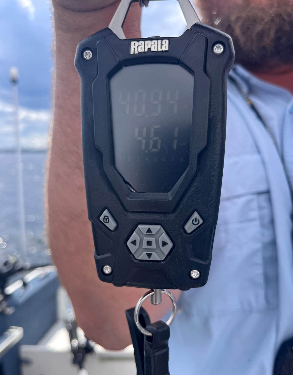 A handheld scale showing the weight of a big muskie.