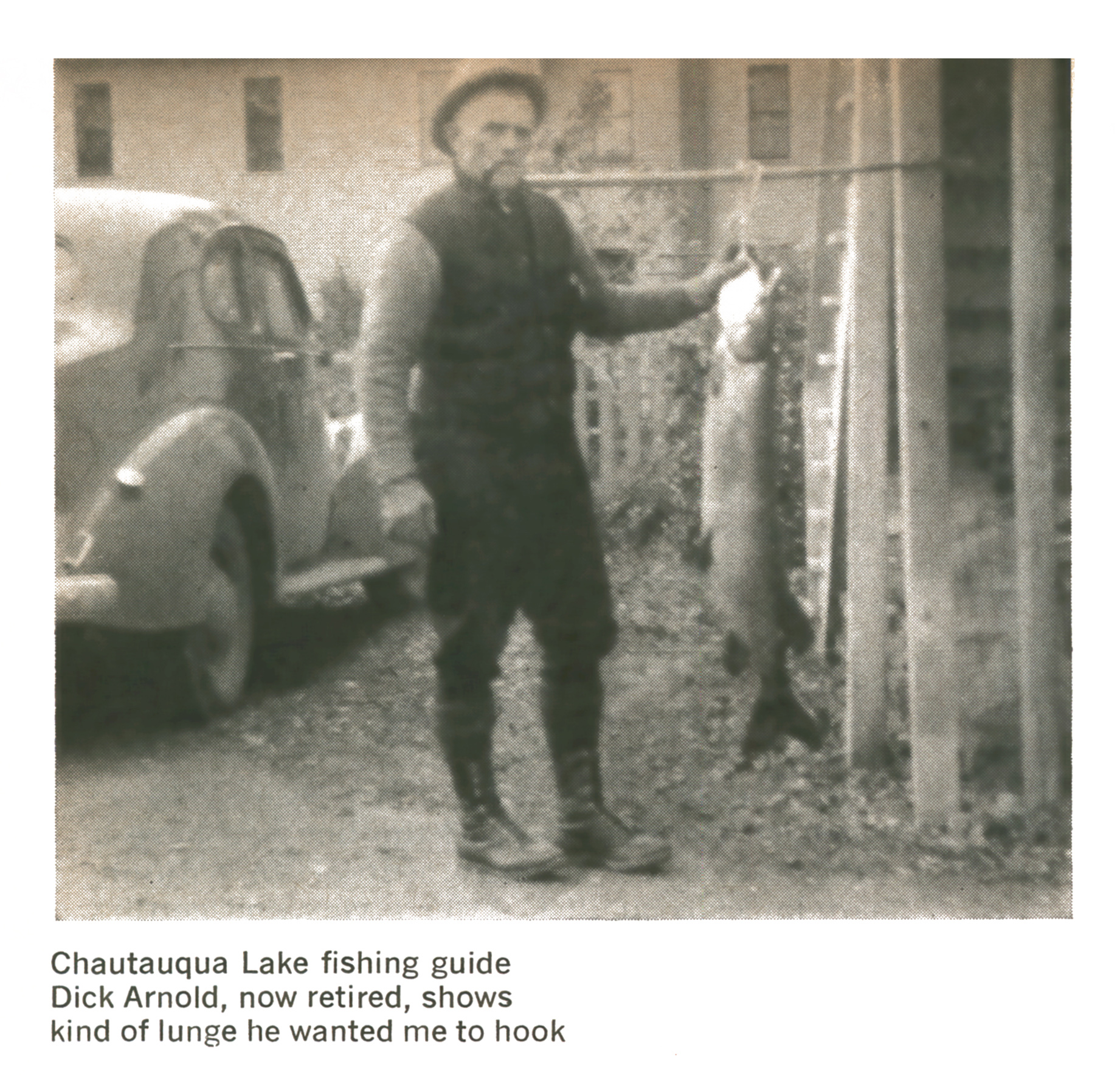 Vintage black-and-white photo of fishing guide Dick Arnold standing beside a 1930s car and holding a long muskie.