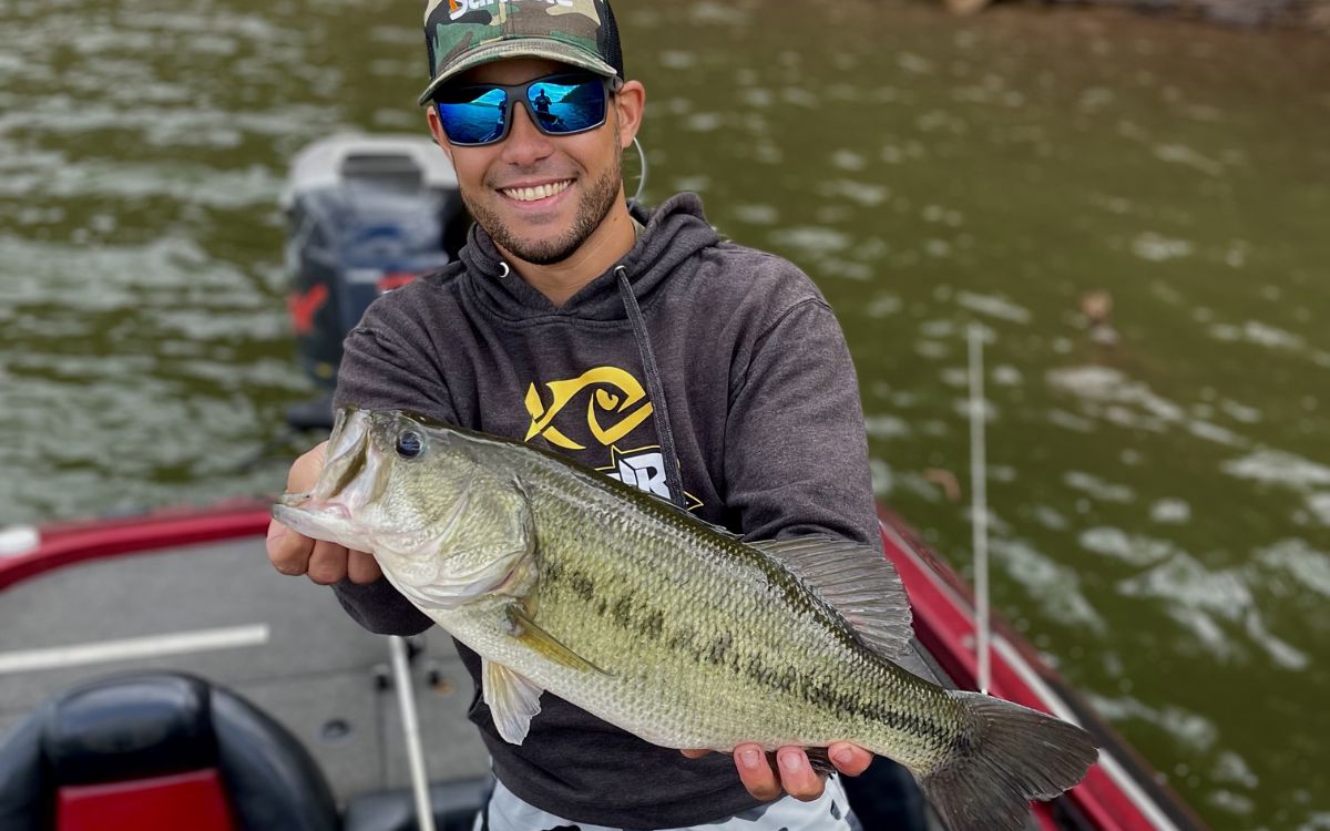 The author holds up a big largemouth bass caught on a DC reel
