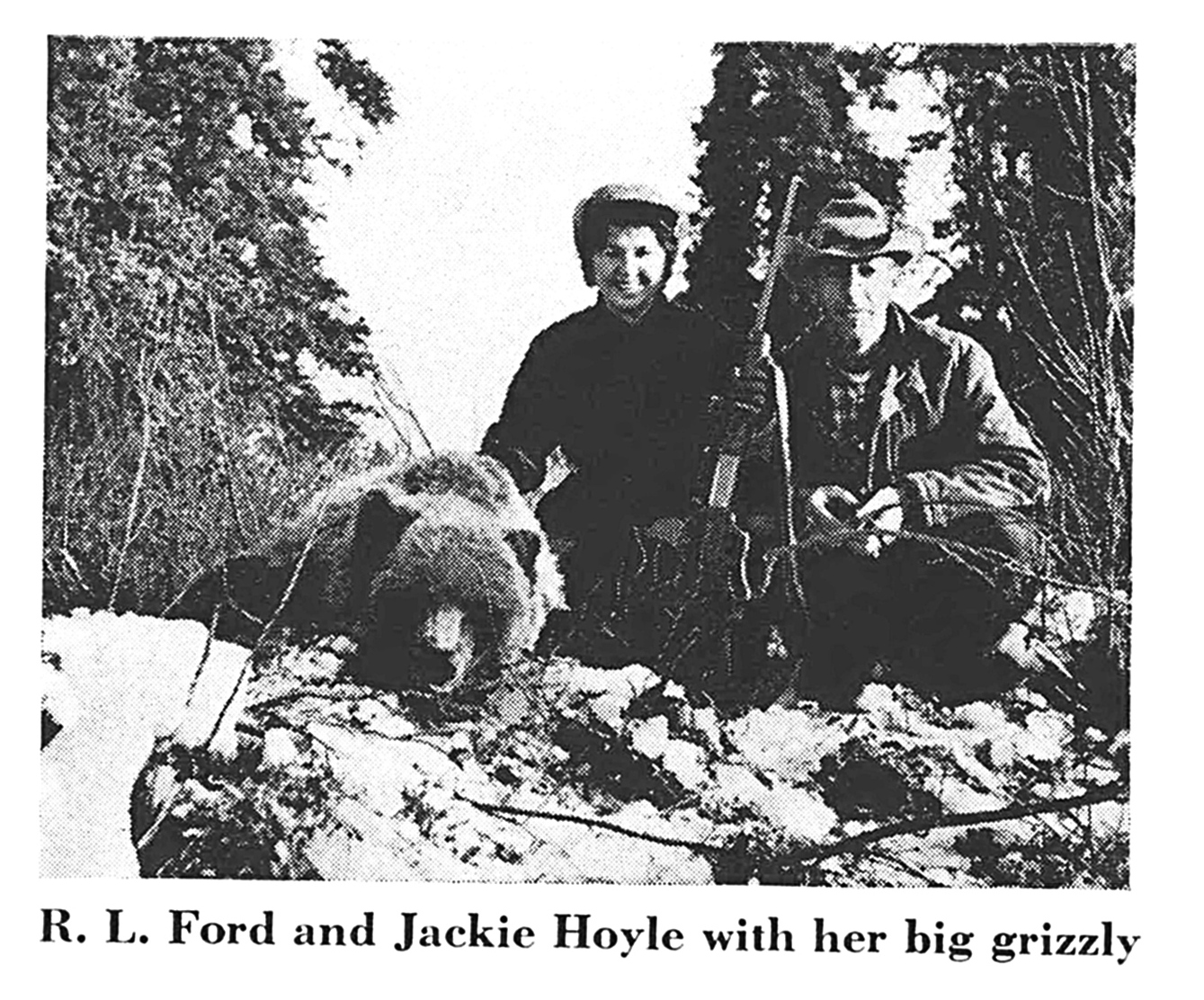 A black and white vintage photo of two hunters and a griz.