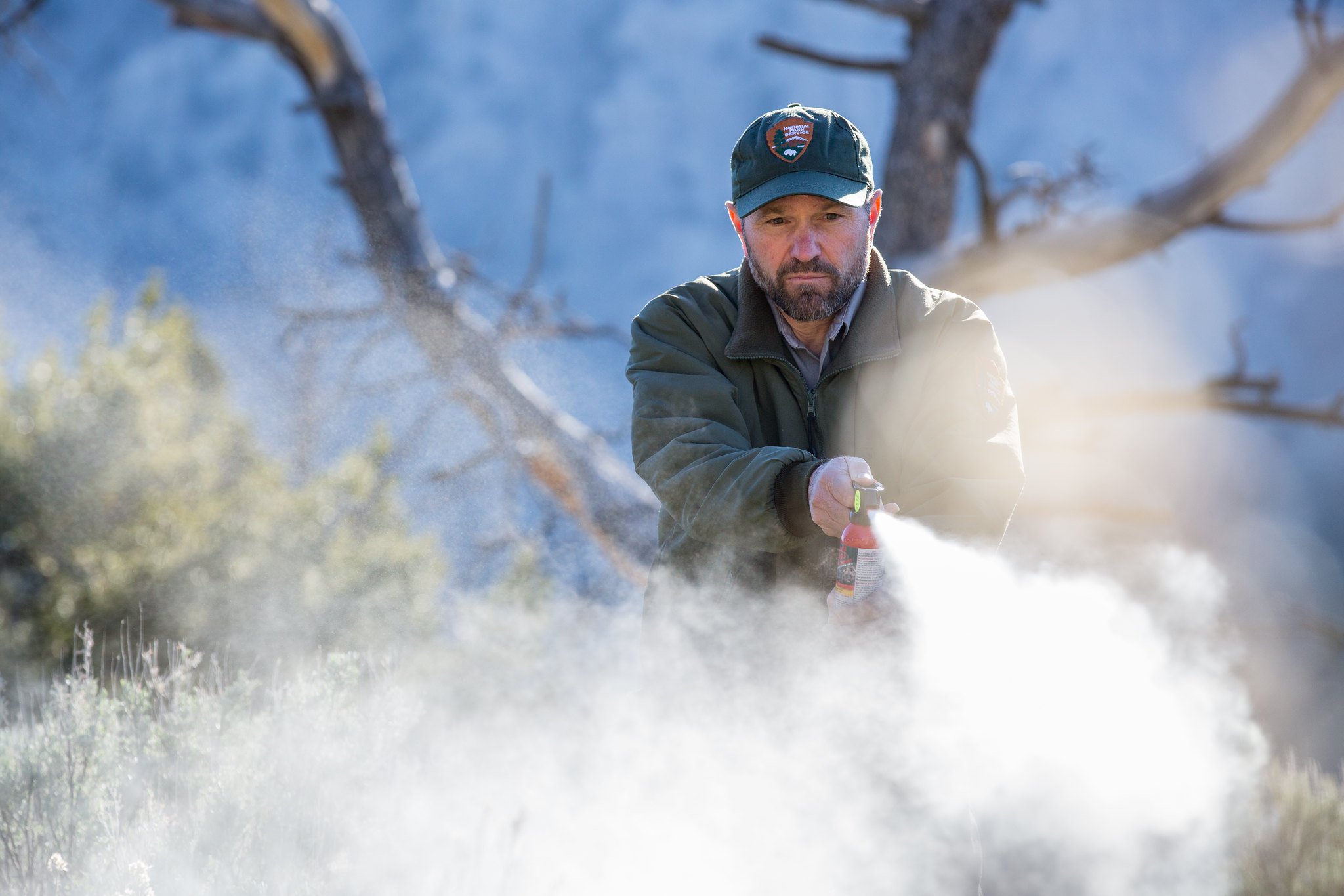 An NPS ranger deploys bear spray.