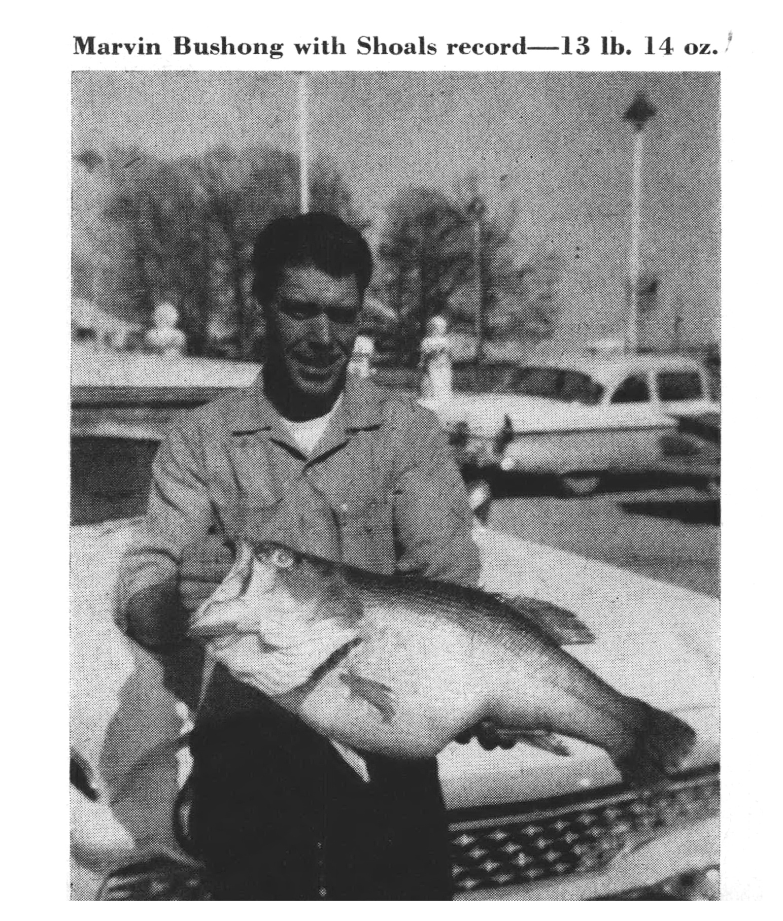 Marvin Bushong holds the record Bull Shoals bass — 13 pounds, 14 ounces — in a lakeside marina lot.