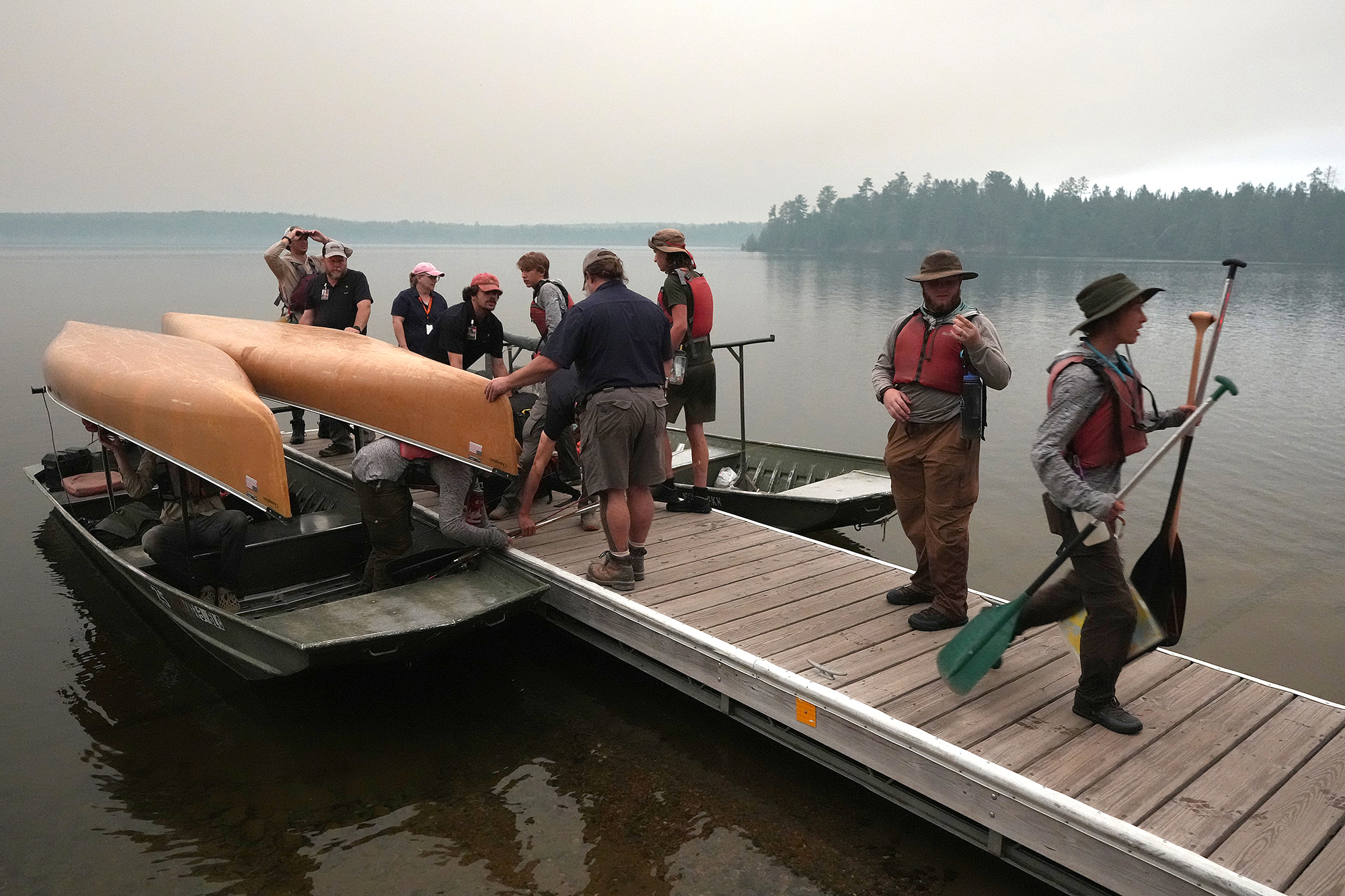 ELY, MN. - JULY 2026: Willy Vosburgh, owner of Vosburgh's Custom Cabin Rentals on Moose Lake, and Patrick Gruenke use a tow boats to evacuate Boy Scout Troop 78 of Boulder, Colo. from the Boundary Waters Canoe Area Wilderness after multiple wildfires burning there prompted its closure and evacuation Tuesday, July 14, 2026 in Ely, Minn. (Photo by Anthony Soufflé/The Minnesota Star Tribune via Getty Images)