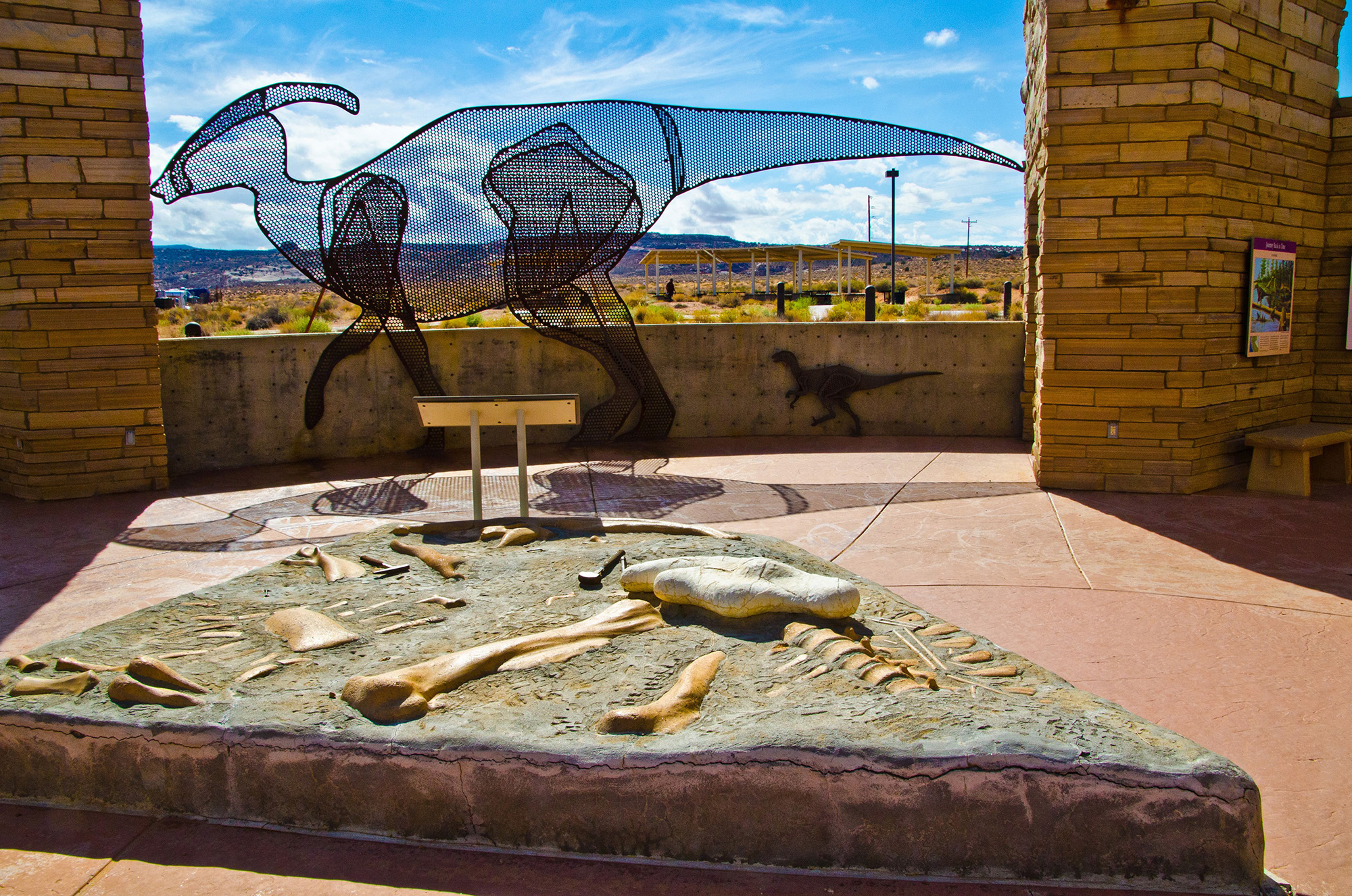 North America, USA, Utah, Big Water, Grand Staircase-Escalante Visitor Center, Entrance Patio Dig Exhibit and Dinosaur sculpture. ()