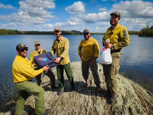 Five USFS employees with a box of pizza in the BWCA.