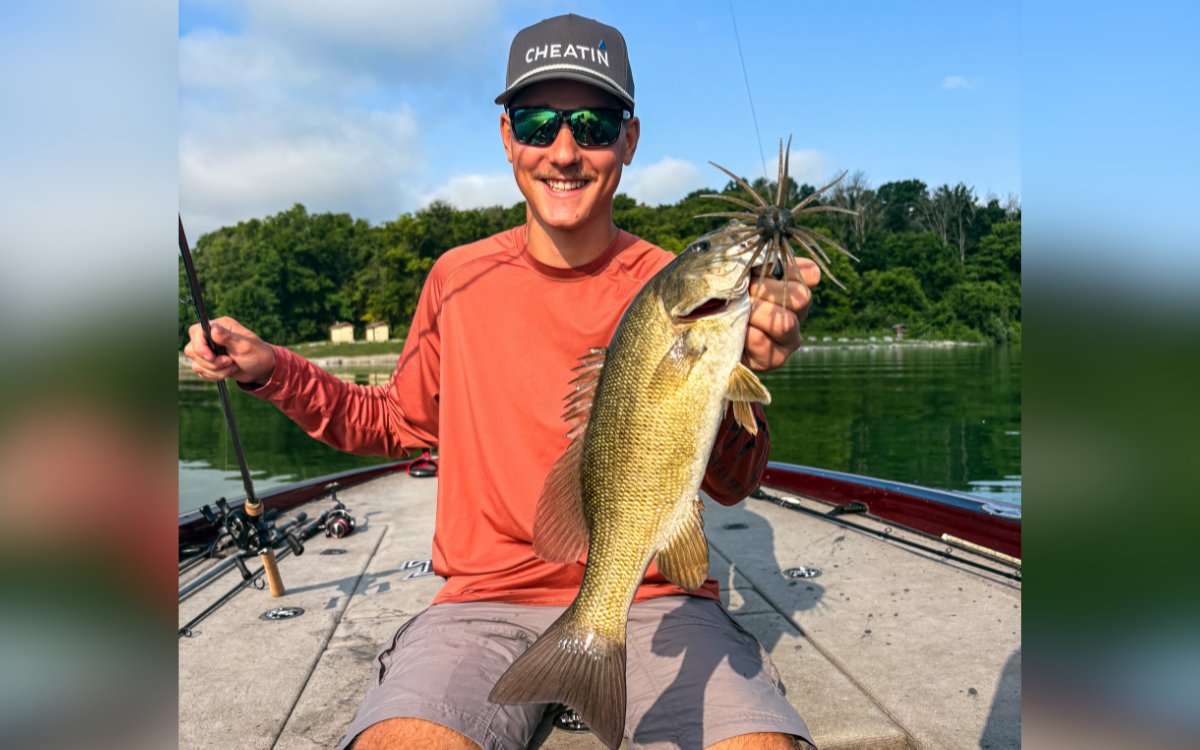 An angler holds up a smallmouth bass caught on a Hideup Coike Fullcast