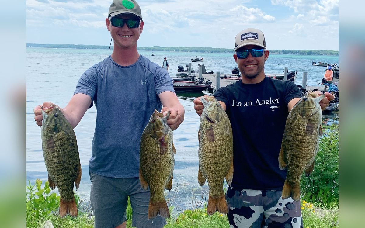 The author and his friend hold up four smallmouth bass they caught in a tournament