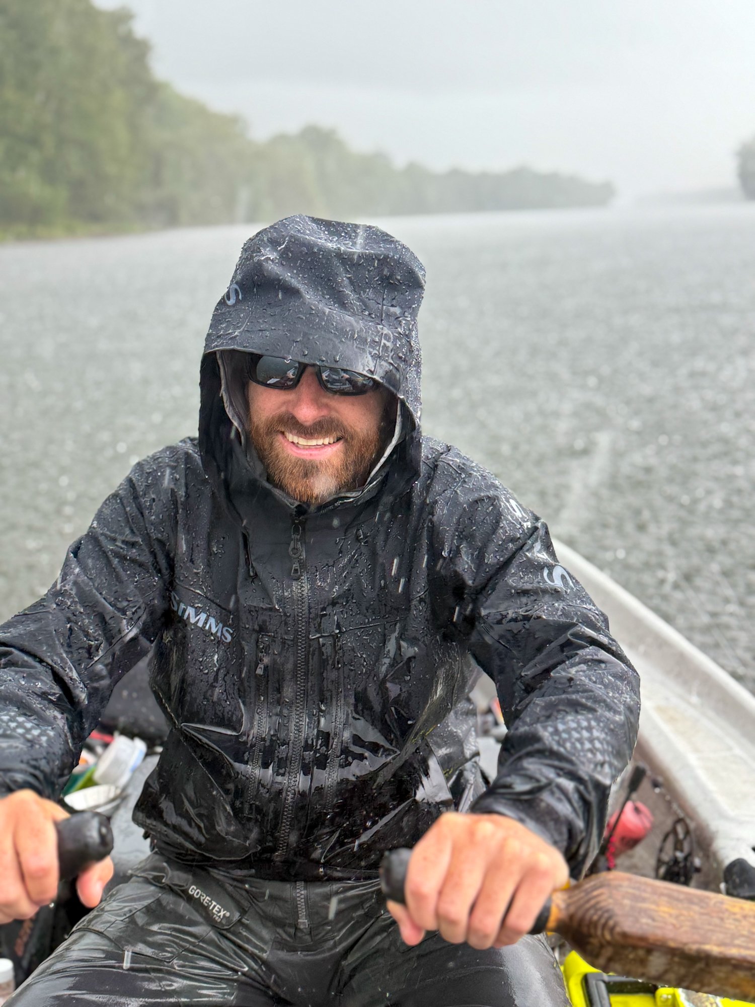 Jake Villwock rows his fishing boat in the rain.