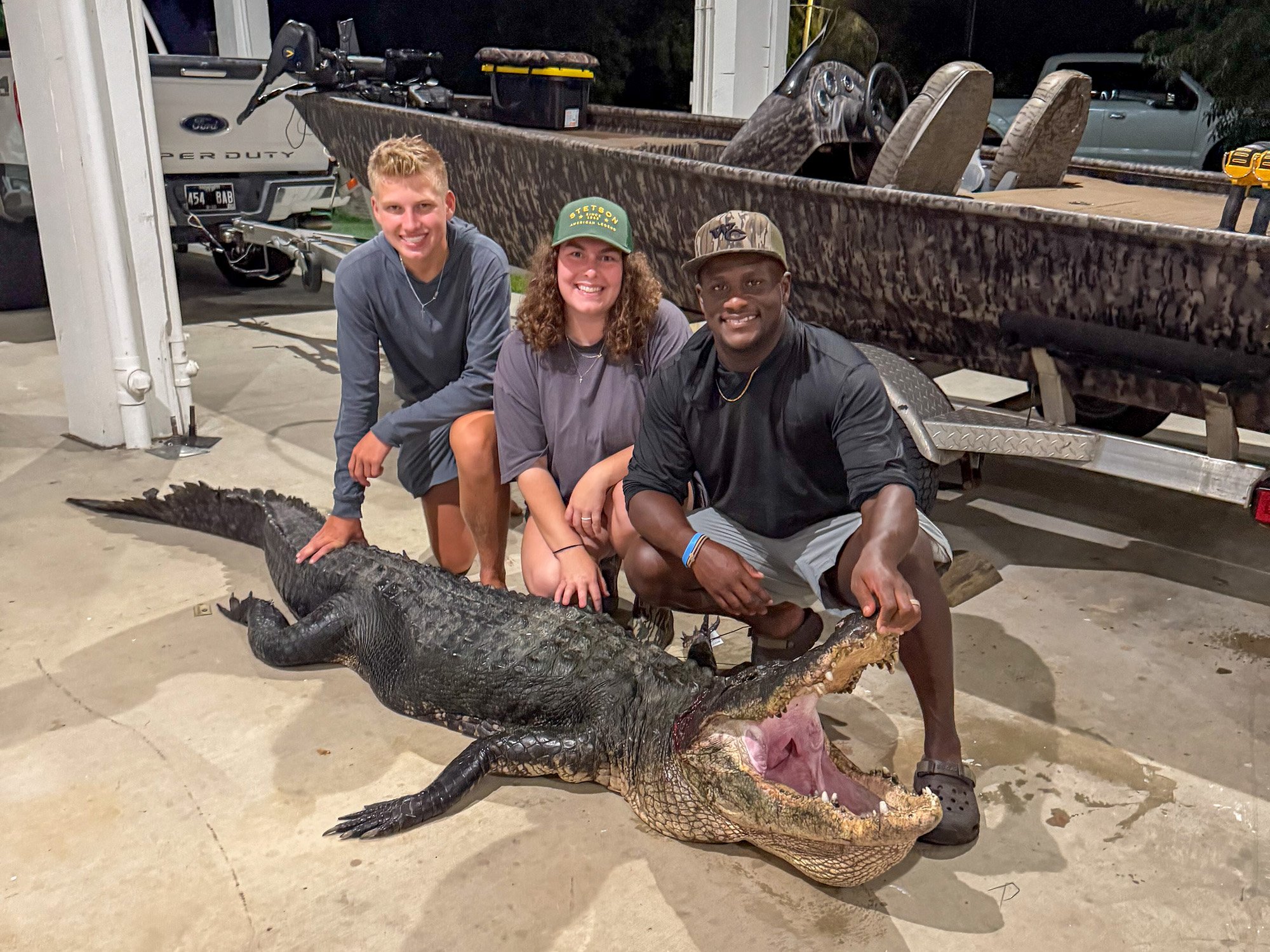 Three people with a gator.
