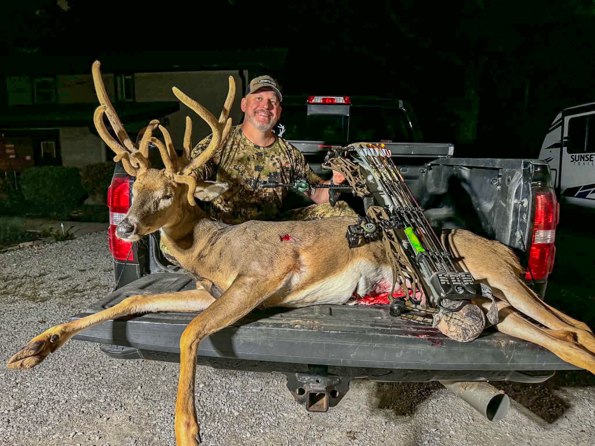 bowhunter with a velvet deer on tailgate